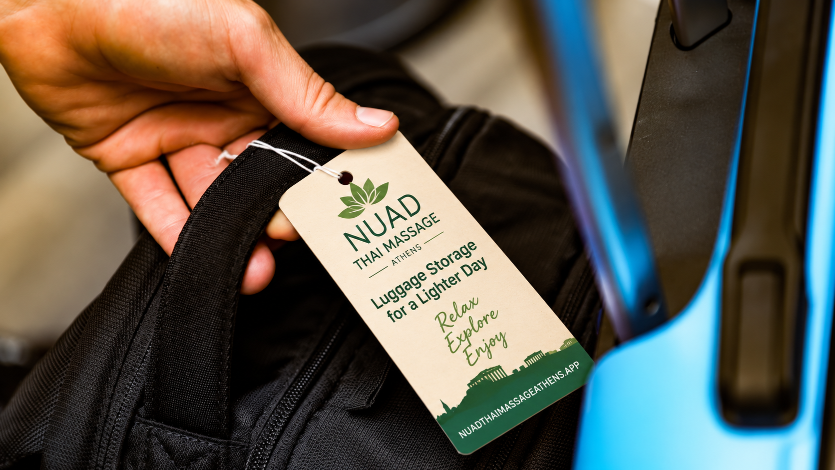 NUAD luggage tag attached to a bag — Athens luggage storage