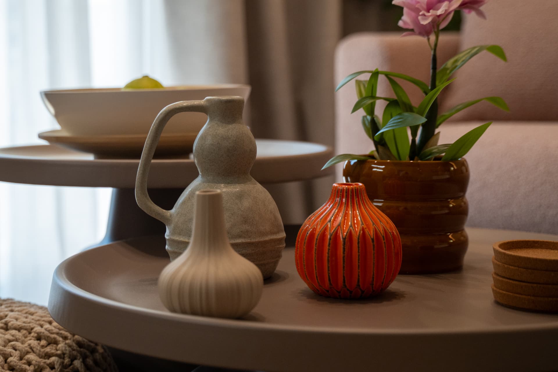 Hand-made clay vases and a potted orchid on a round table in the retreat suite