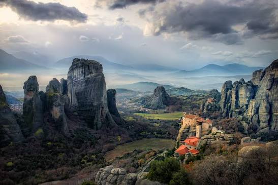 The rock pillars and monasteries of Meteora under dramatic clouds — a full-day tour from Athens
