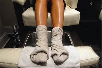 Feet wrapped in warm towels during a foot mask spa treatment