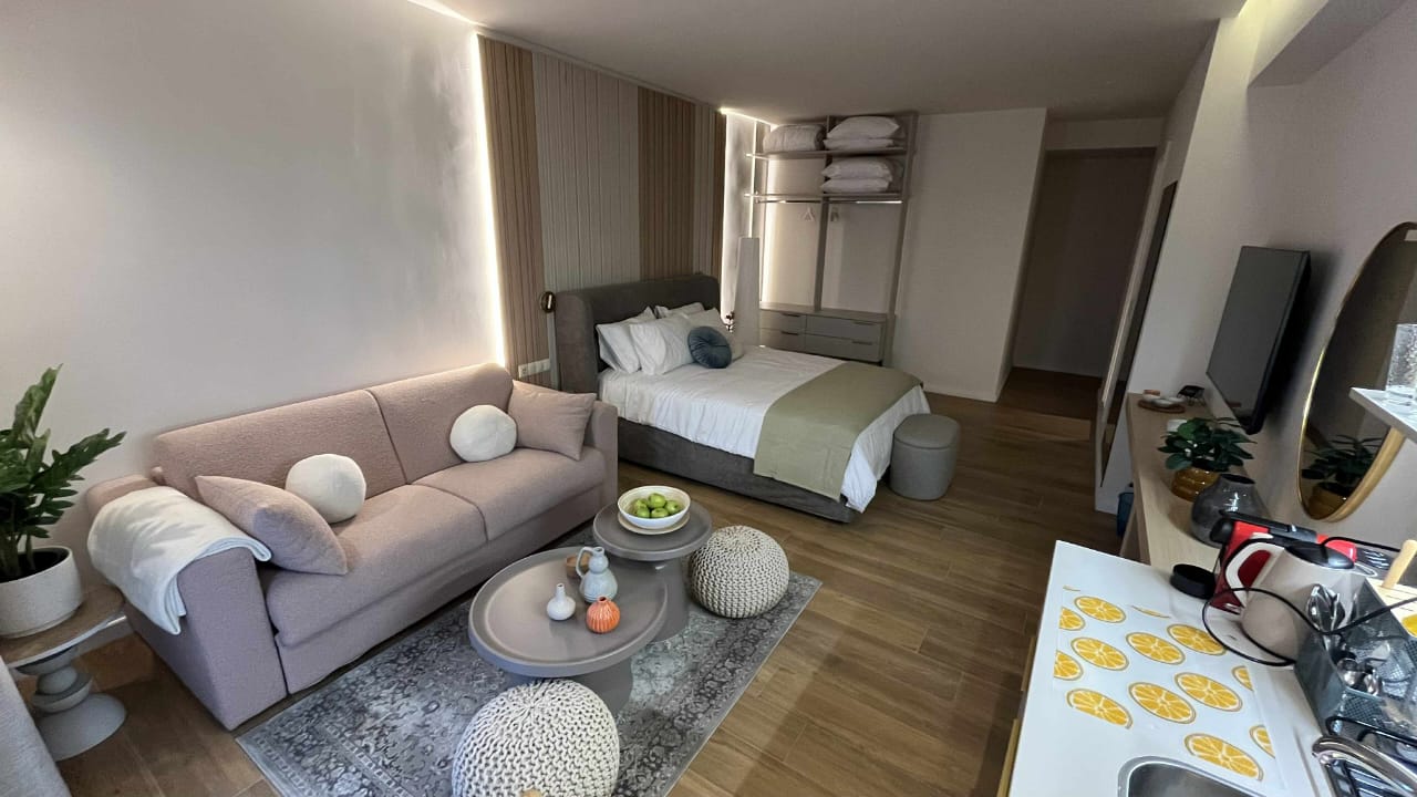 Compact luxury suite with a single bed and sofa nook