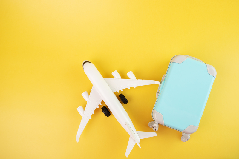 Model plane and suitcase ready for the airport — we arrange your airport taxi at no commission