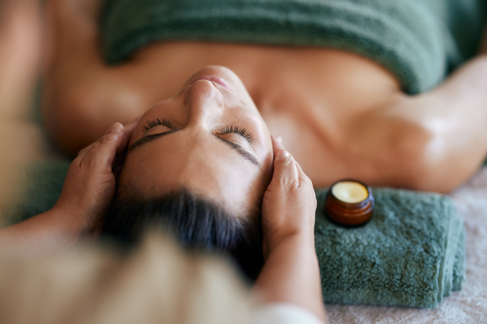 Aromatherapy oils and poppies beside a massage bed