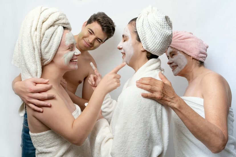 Family of four generations in towels enjoying face masks together