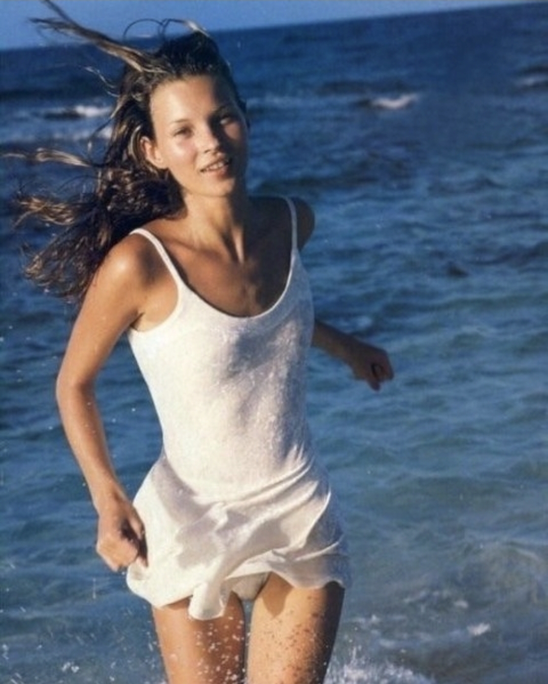 Woman running through ocean water, feeling free and healthy