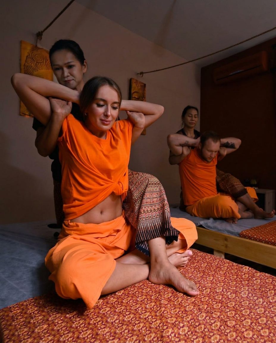 Sciatica Relief Therapy at Nuad Thai Massage Athens — seated back stretch on a traditional floor mattress
